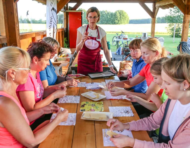 Käsitööõpituba õues, naised õpivad käsitööd laua taga.